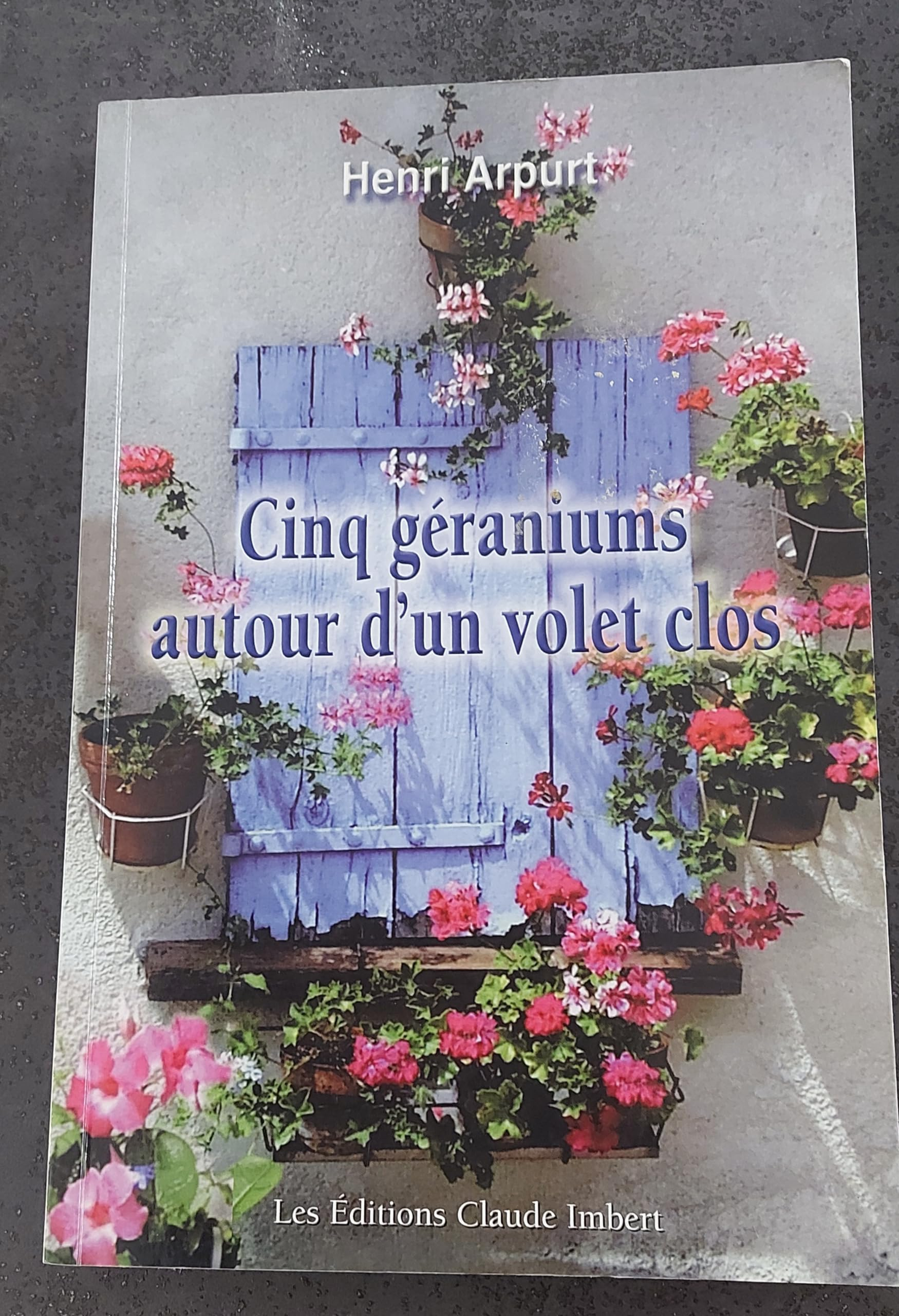 Cinq géraniums autour d'un volet clos